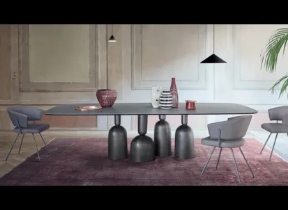 Tavolo Cop con piano in ceramica e base in metallo formata da elementi stilizzati ispirati a bottiglie, calici preziosi e coppe di champagne di Bonaldo